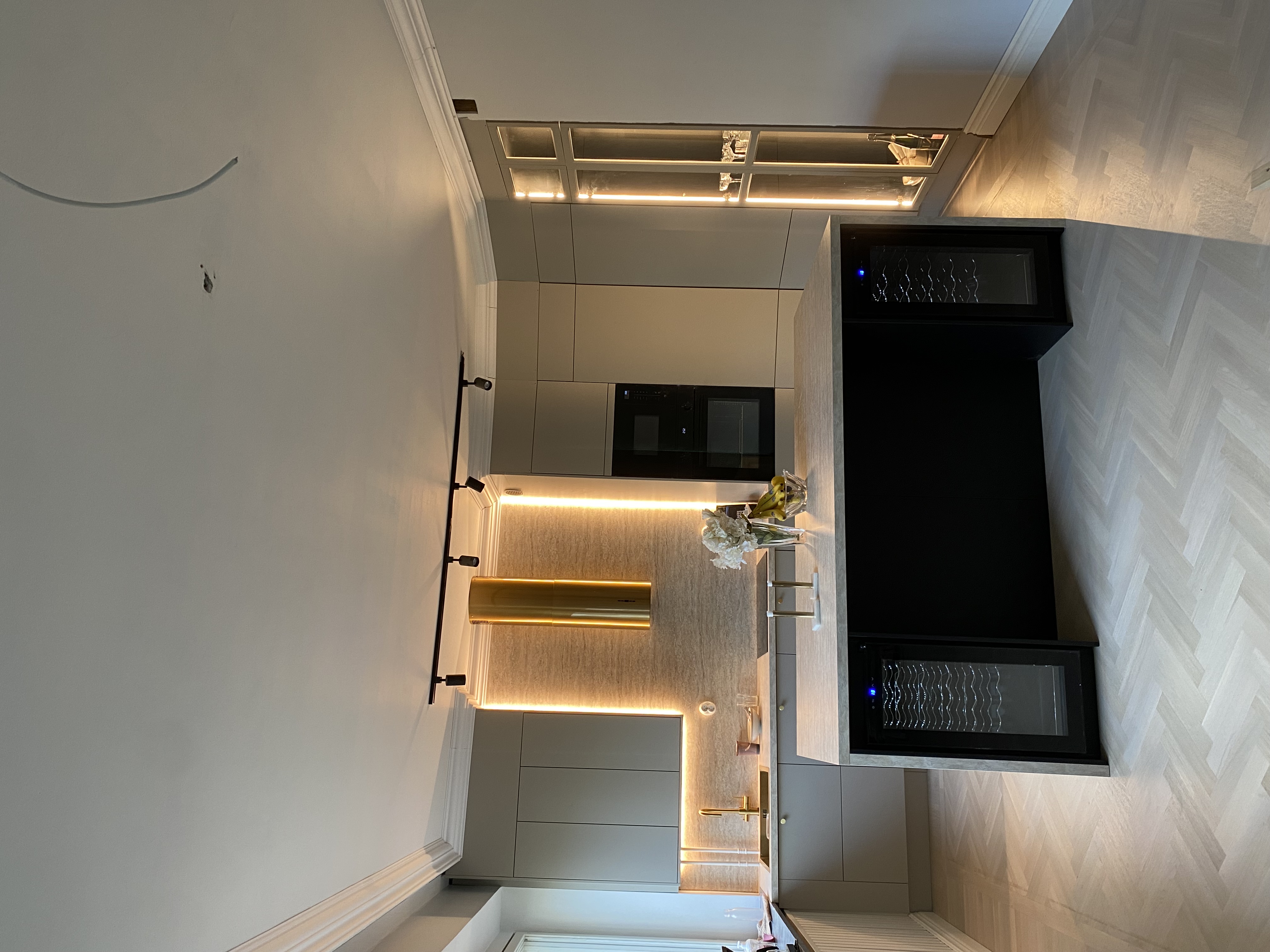 Modernt kök med beige skåp och gulddetaljer